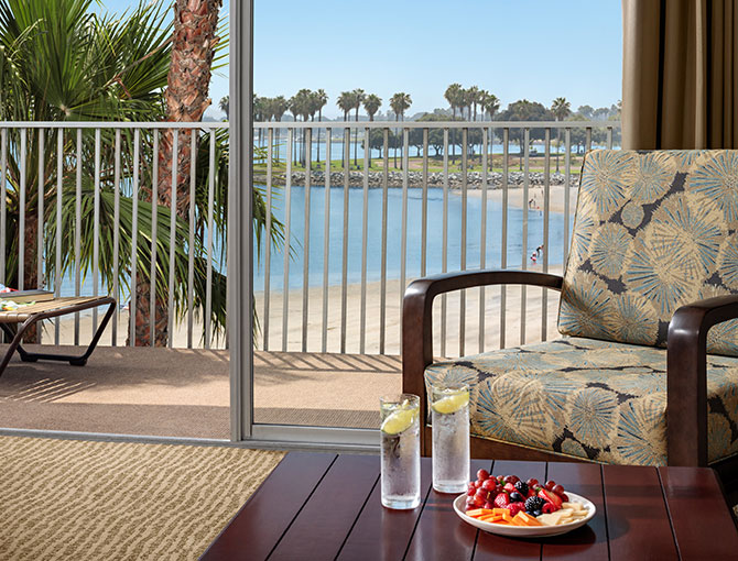 Bay View Suite living area with a balcony overlooking Mission Bay at the Bahia Resort Hotel in San Diego